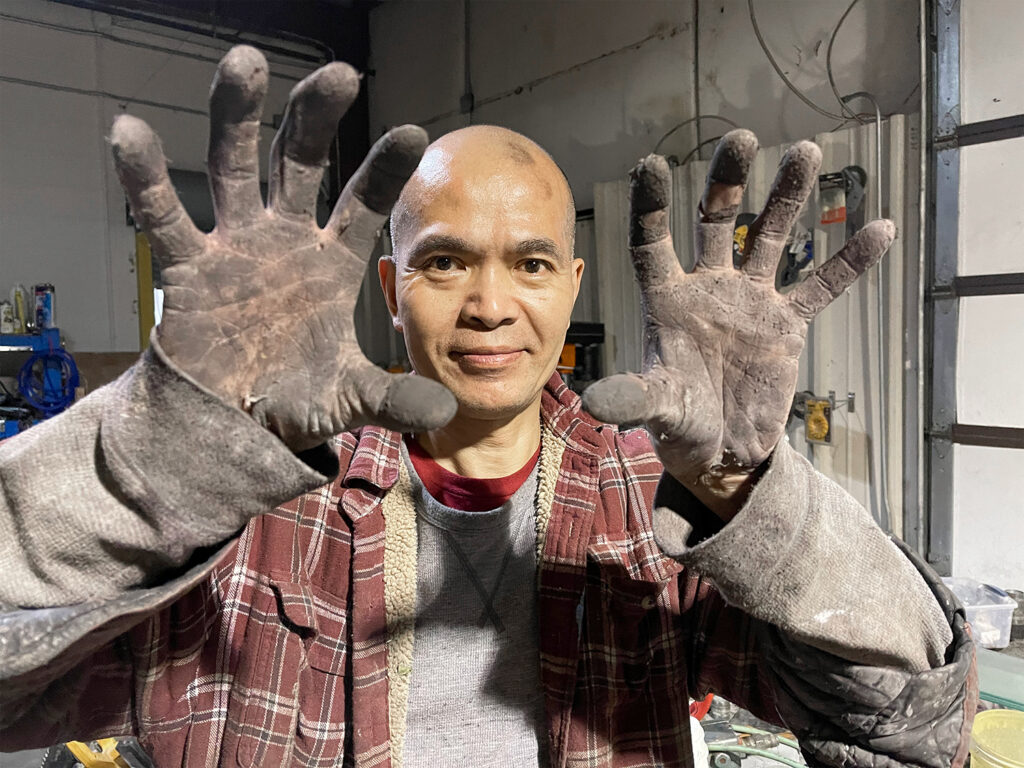 Everkem CEO and Head of Operations, Chin Lin showing hands dirty from working on a machine